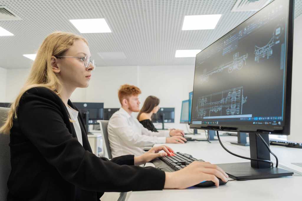 a woman who is working on a computer in an office