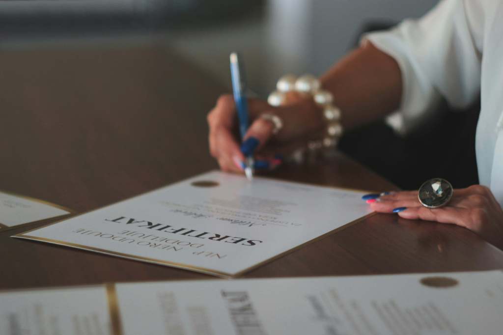 A woman who is signing a certificate